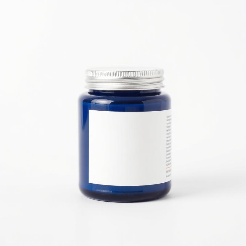 Dark blue jar of joint and muscle therapy cream with a silver lid on a white background
