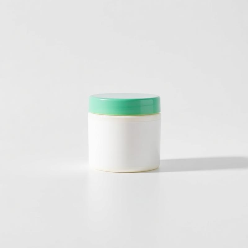White tub of arthritis relief cream with a green lid on a white background